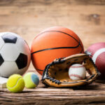 high angle view of various sport accessories on textured wooden surface